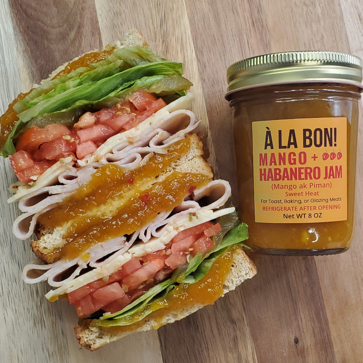 Mango Habanero jam drizzled on a stacked turkey sandwich with lettuce and tomato