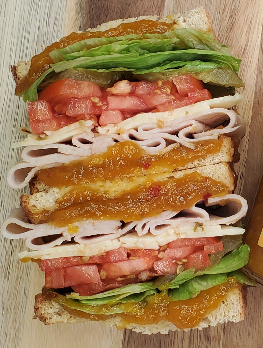 Close-up of Mango Habanero jam layered through a stacked sandwich